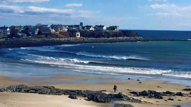 A coastal town with a beach, rocky shoreline, and houses along the cliff. - HAMPTON BEACH OCEANFRONT HOME SITUATED ON GREAT BOARS HEAD (Hampton)