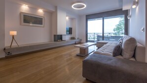 Un saló modern amb un sofà, una taula de centre, una televisió i una xemeneia.