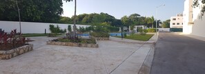 Stroll along the paved walkway, surrounded by lush greenery and a serene pool.
