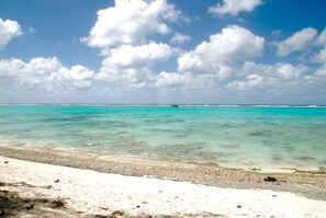 Una spiaggia con acque turchesi cristalline e una battigia sabbiosa.