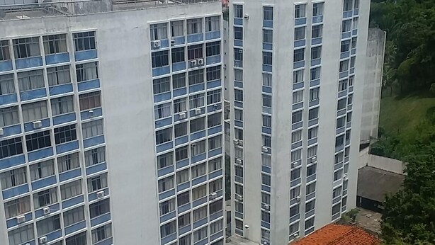 A high-rise building with multiple floors, large windows, and a flat roof.