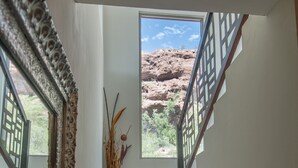A staircase with a view of a rocky landscape through a window. - Dream house OCEAN VIEW San Carlos (SAN CARLOS)