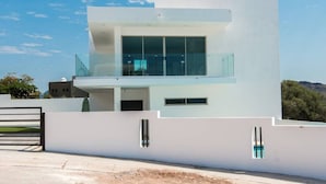 A modern two-story house with a balcony, large windows, and a white exterior. - Dream house OCEAN VIEW San Carlos (SAN CARLOS)