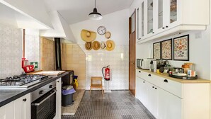 A modern kitchen with a gas stove, microwave, and cabinets. - Cottage in Amarante-Porto (Amarante)