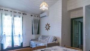 A bedroom with a bed, a sofa, a table, and a hanging light fixture. - Residence Pinnetta - 6-seater apartment with free pool and WiFi (Calabitta)