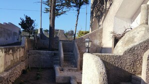 A stone pathway leading to a staircase surrounded by stone walls, with a tree and a lamp post visible. - VILLA ALDA TWO ROOMS APARTMENT - Apartment with Enchanting View (Santa Cesarea Terme)