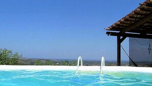 Une piscine à l’eau d’un bleu cristallin, une terrasse en bois et une vue imprenable sur le paysage.