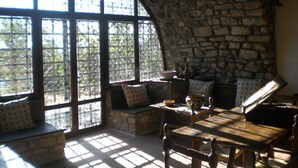 A rustic room with stone walls, a wooden table, and a bench.