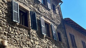 A stone building with multiple windows and arched doorways.