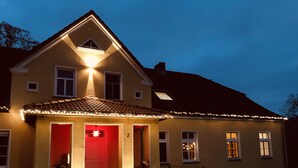 Une maison à deux étages avec une porte rouge et le chiffre « 2 » peint sur le mur.