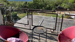 A balcony with a view of mountains, a potted plant, and two red chairs. - Pleasant house in Luberon with swimming pool, France (Viens)