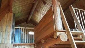 A rustic wooden interior with exposed beams and a sloped ceiling.