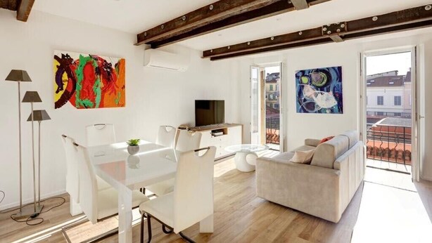 A modern living room with a dining area, a sofa, a TV, and artwork on the walls. - T2 Marché de Forville CANNES (Cannes)