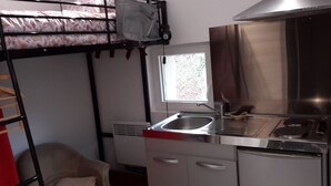 A compact kitchen with a bunk bed, a window, and a sink. - Mini gîte, studette  (Bonny-sur-Loire)