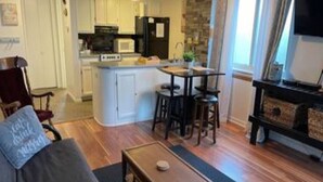 A compact living space with a kitchenette, a dining area, and a seating area. - Baby Bear HideAway (Gatlinburg)
