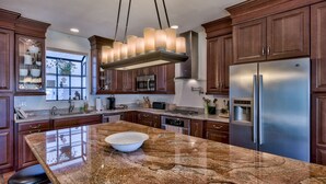 A modern kitchen with granite countertops, stainless steel appliances, and wooden cabinetry. - Destin Festival!!  Sept 24 - 28  Available (Miramar Beach)
