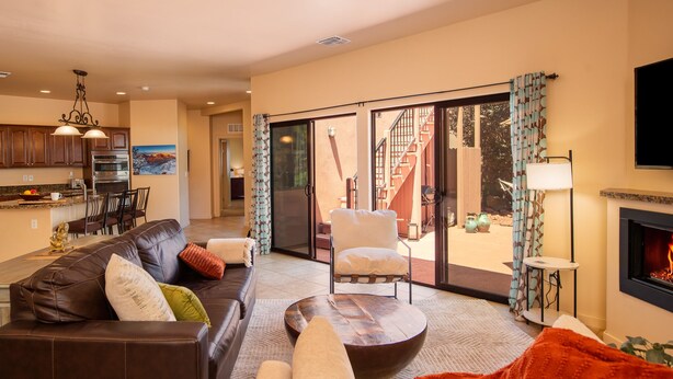 Una sala de estar moderna con chimenea, comedor y cocina.