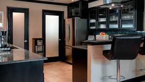 Een moderne keuken met een centraal eiland, roestvrijstalen apparatuur en zwarte kastjes.