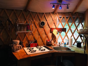 Una cocina acogedora con detalles de madera, una estufa a gas, un fregadero y diferentes utensilios de cocina.