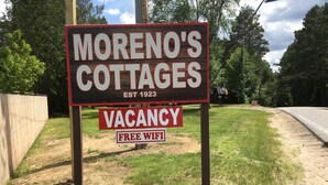 Une pancarte indiquant les disponibilités et la présence d’une connexion Wi-Fi gratuite aux « Moreno’s Cottages ».
