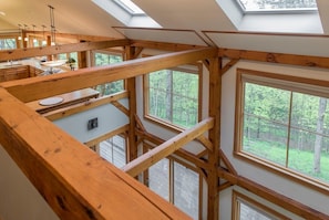 Eine mehrstöckige Holzkonstruktion mit Dachfenstern, einer Küchenzeile und großen Fenstern mit Blick ins Freie.