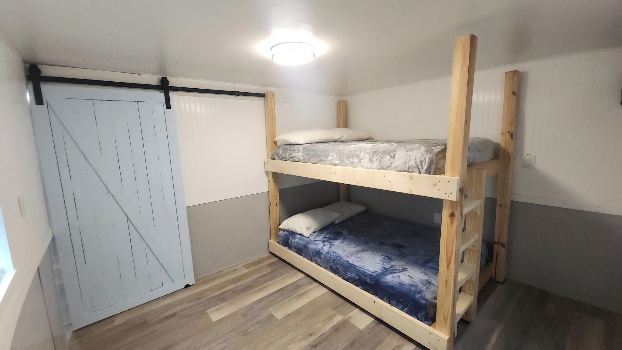 A bunk bed room with a sliding door and a ceiling light.