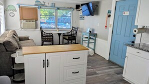 A compact kitchen with a wooden countertop, white cabinets, and a blue door. - Home on canal near Rogers Park, 2 docks, water access to the Gulf, sleeps 10 (Weeki Wachee)