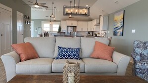 A living room with a sofa, a patterned armchair, and a wooden coffee table. - Steps to Beach*Private Heated Pool*Elevator* Jennette's Pier (Nags Head)