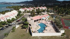 Ein Resort mit Schwimmbad, Liegestühlen und Meerblick.
