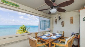 Ein Essbereich mit Meerblick, Deckenventilator und tropischer Einrichtung.