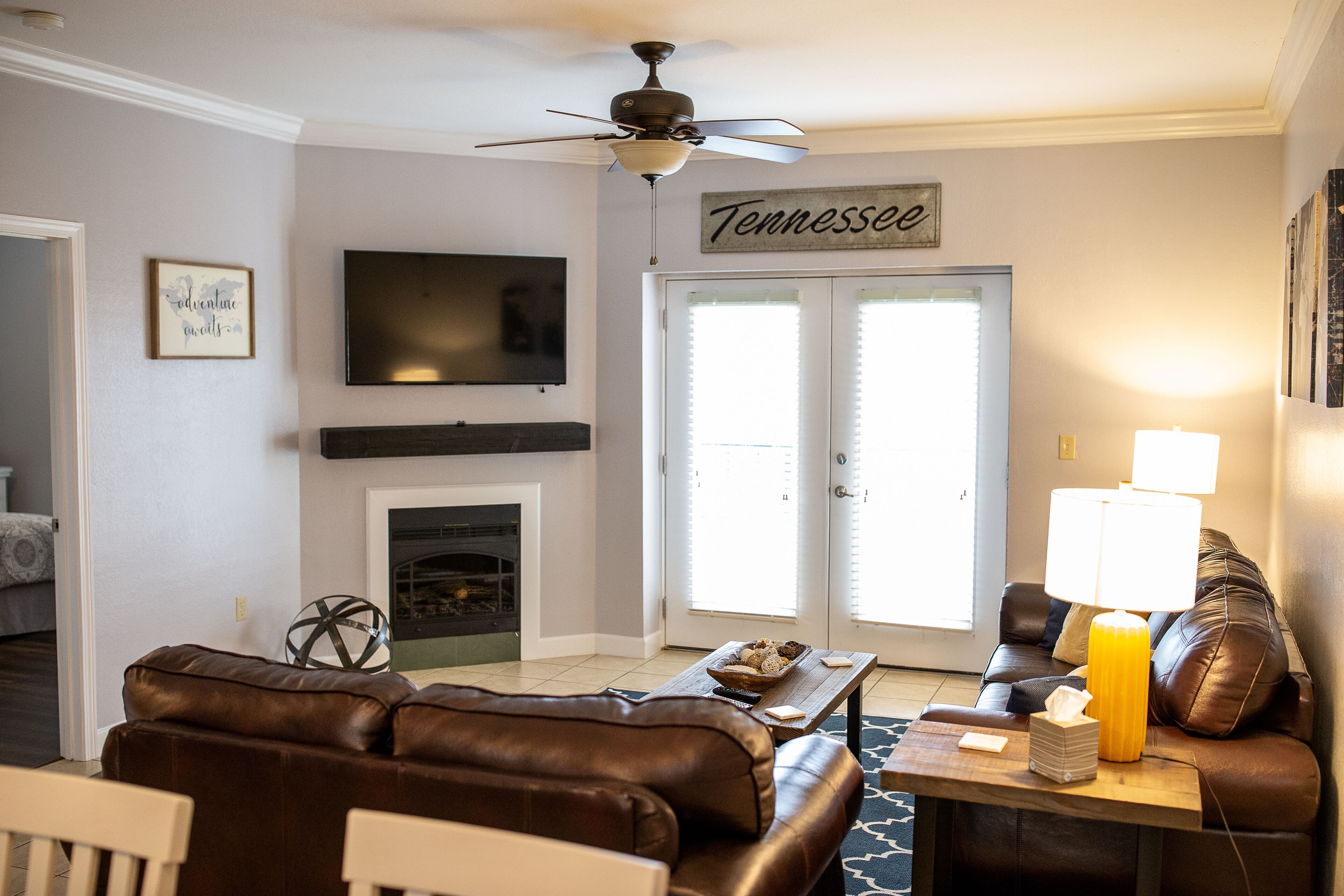 A living room with a fireplace, a television, and a sign that says 'Tennessee'.
