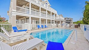 A pool area with multiple levels of balconies, white railings, and blue lounge chairs. - Semi-Oceanfront Home w/ Private Pool, Hot Tub, Elevator, Game Room, and Wet Bar (Salvo)
