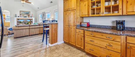 A spacious kitchen with wooden cabinets and a granite countertop.