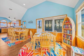 Un comedor con muebles de madera, una alfombra colorida y una estantería llena de libros.