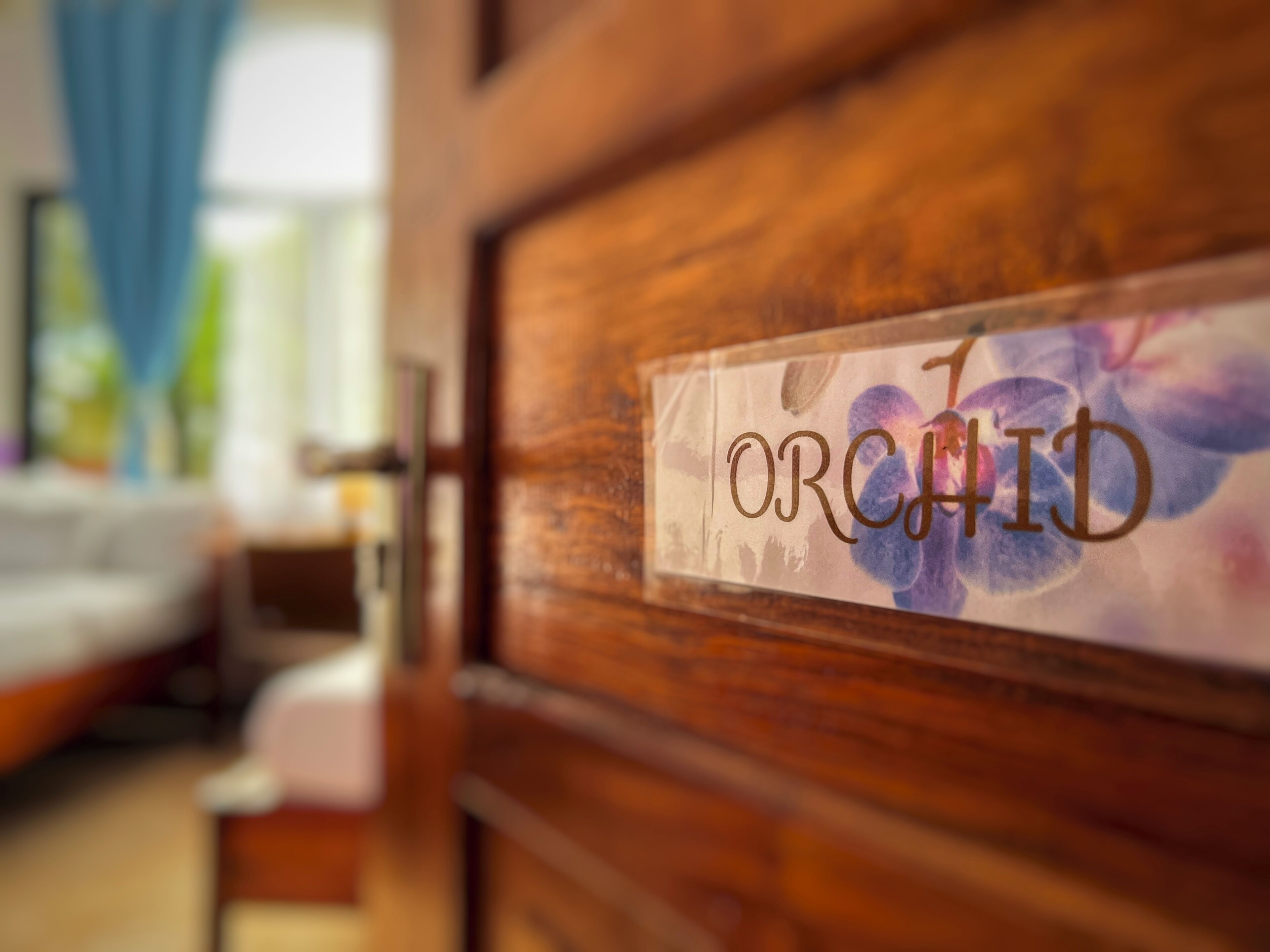 A wooden door with a sign that reads "ORCHID" and a floral design.