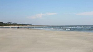 A wide sandy beach with gentle waves and a clear sky. - Serene Oceanfront Getaway Cherry Grove (North Myrtle Beach)3BR (North Myrtle Beach)