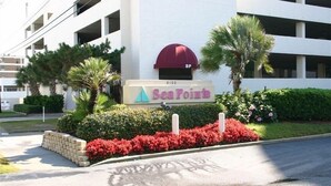 A building with a sign reading "SeaPoint" and a red awning. - Serene Oceanfront Getaway Cherry Grove (North Myrtle Beach)3BR (North Myrtle Beach)