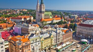 A historic cityscape with a prominent church tower, a bustling square with market stalls, and a variety of traditional buildings. - Apartment in Zagreb with Terrace, Air condition, WIFI, Washing machine (3798-1) (Zagreb)
