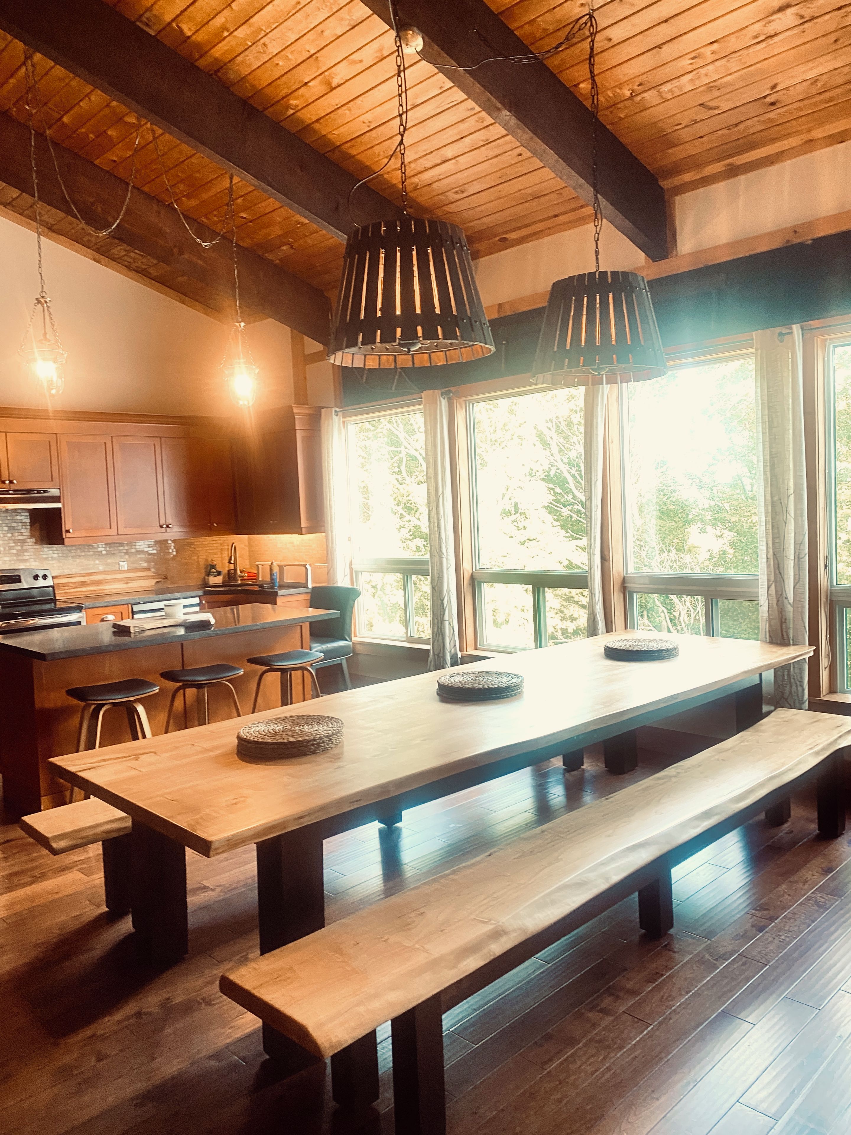 A spacious kitchen with wooden cabinets, a large island, and pendant lighting.