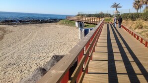 A wooden boardwalk leading to a beach with a clear sky. - villa halcyon 24 calle huelva calahonda (Mijas)
