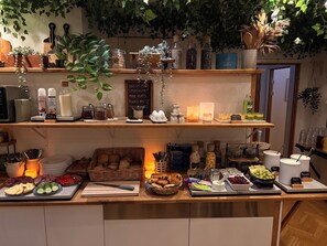 Een overzichtelijk buffet met diverse gerechten, sauzen en drankjes.