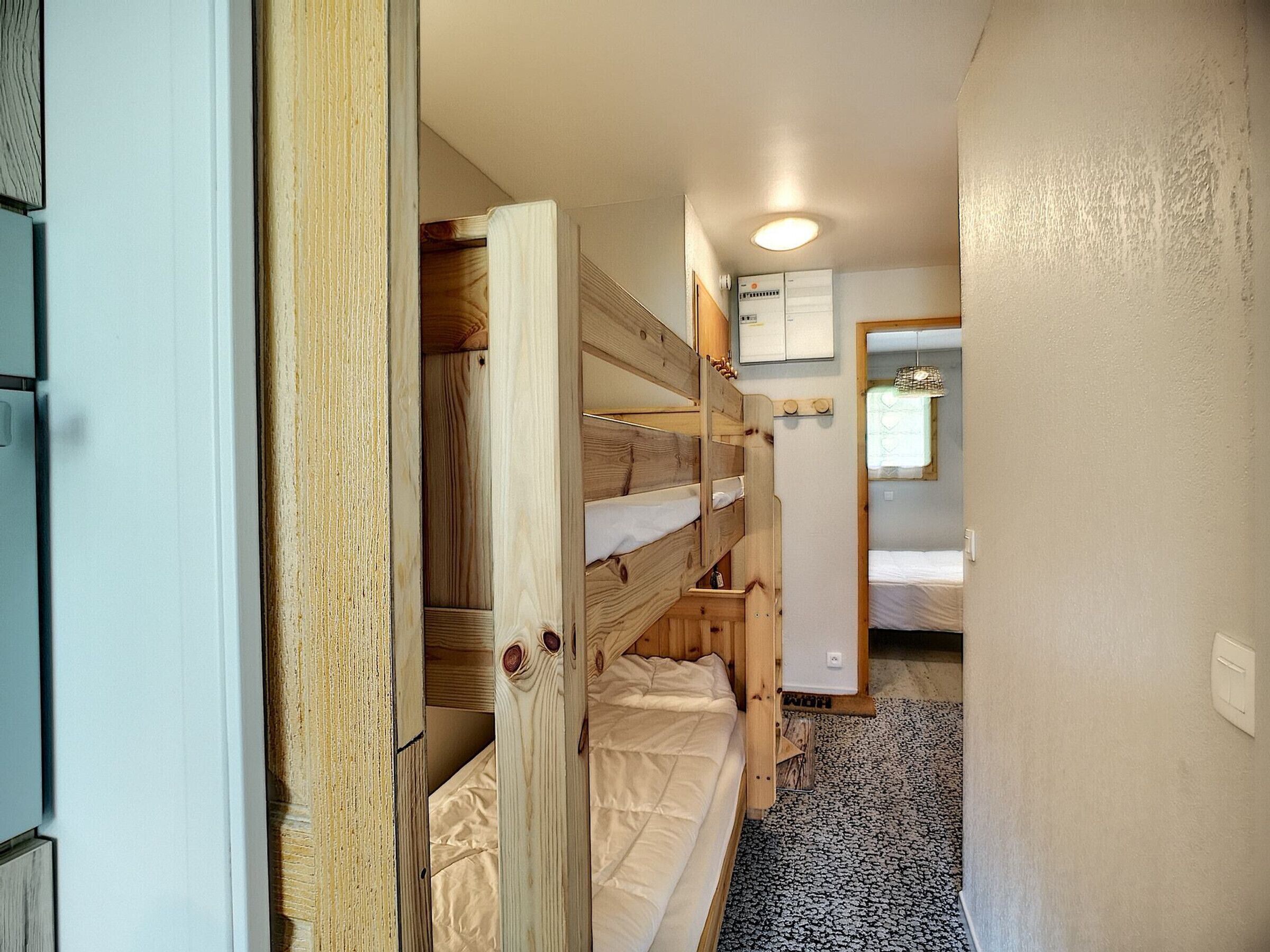 Ein schmaler Korridor mit Holzwetten, einer kleinen Küchenzeile und einem Badezimmer mit Dusche.