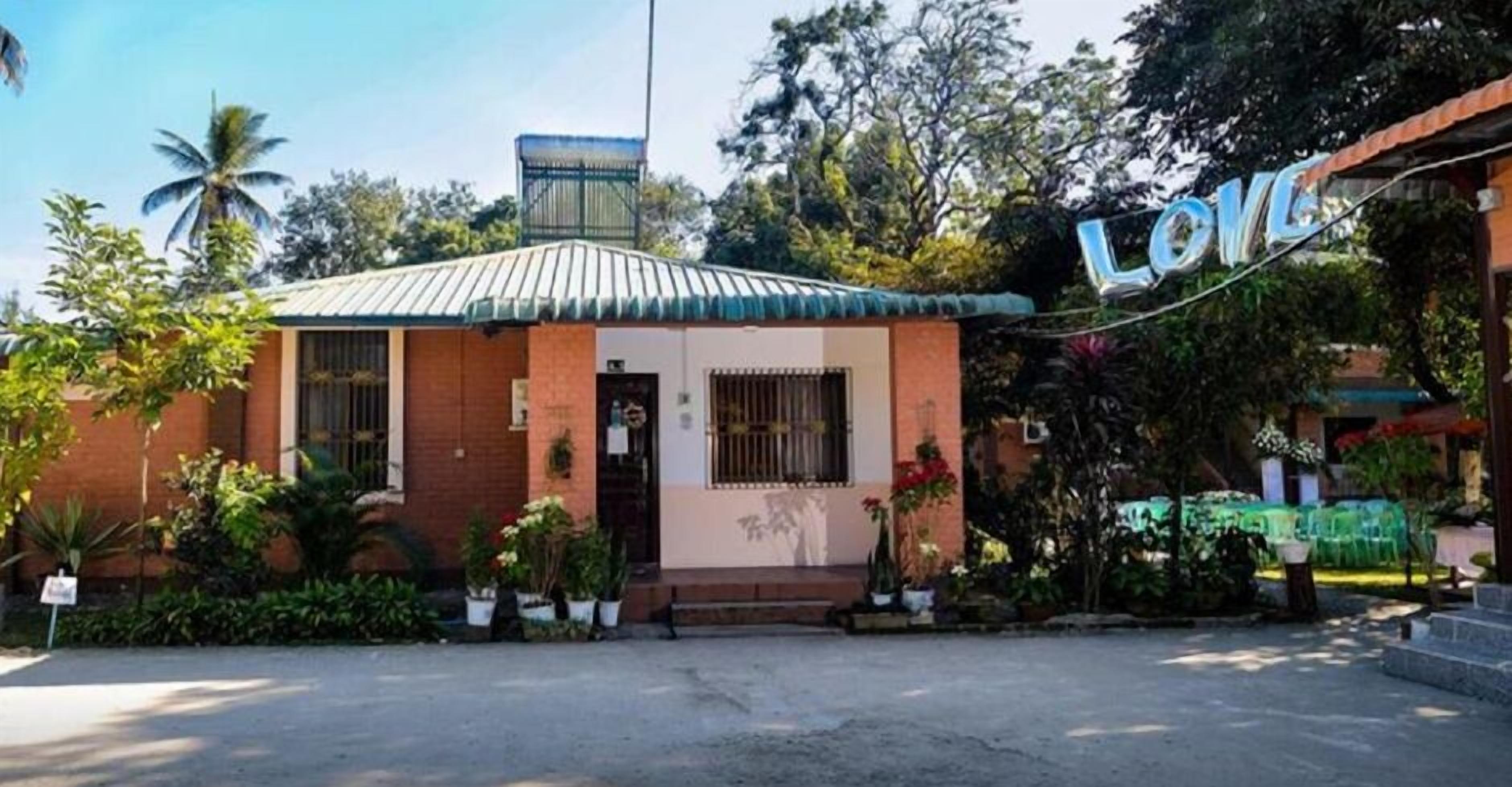 Un petit bâtiment avec un toit en tôle ondulée, une façade en briques et une enseigne sur laquelle on peut lire le mot « AMOUR ».