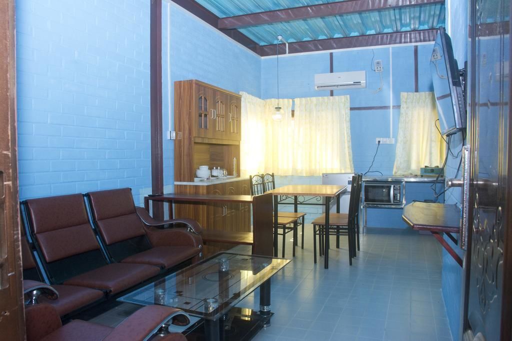 A compact living space with a sofa, dining table, and kitchen area.