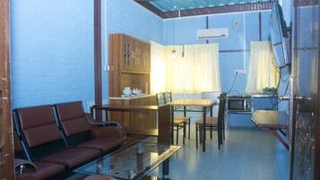 A compact living space with a sofa, dining table, and kitchen area.
