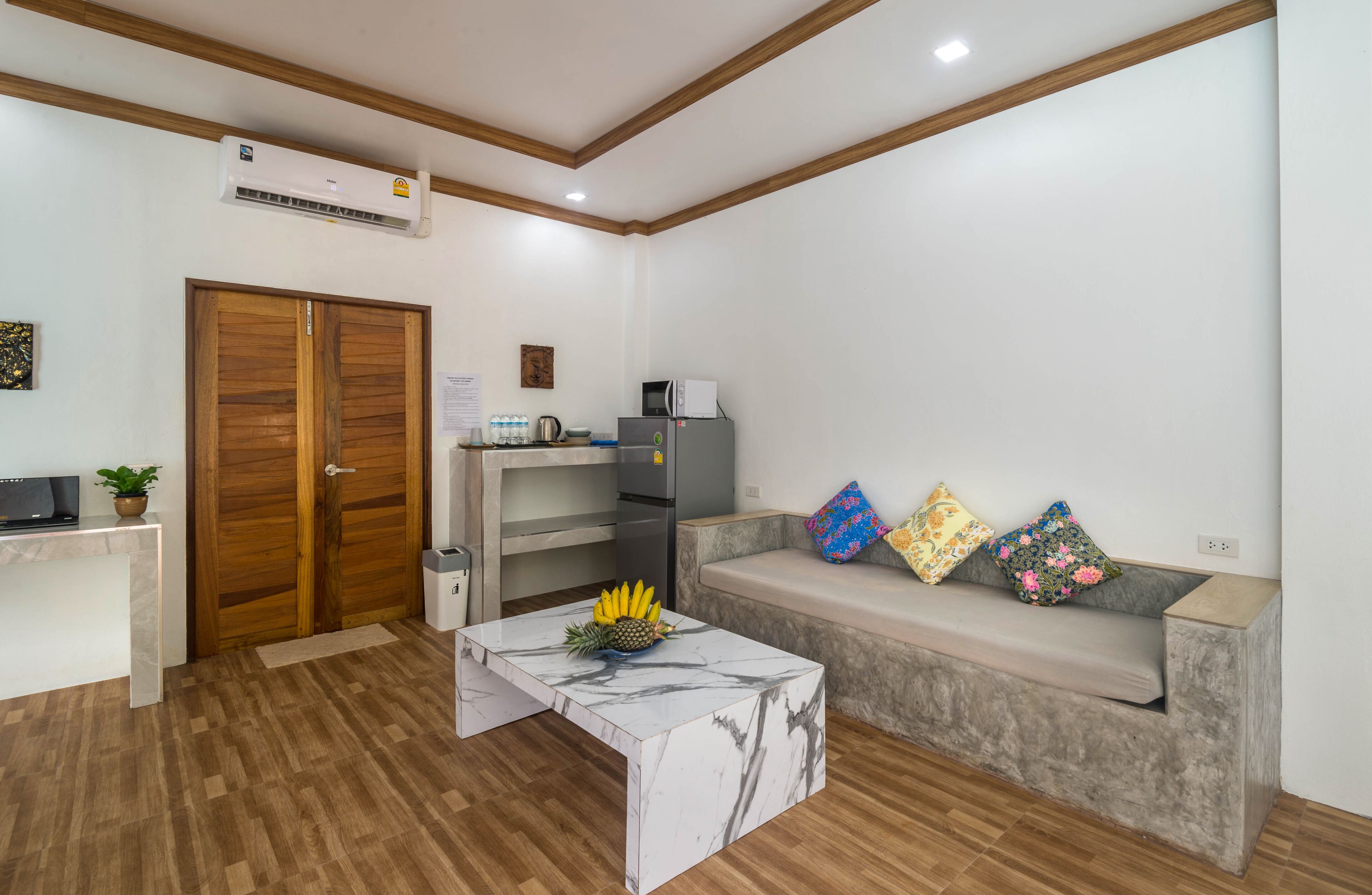 A modern kitchen with a built-in microwave, a refrigerator, and a wooden door.