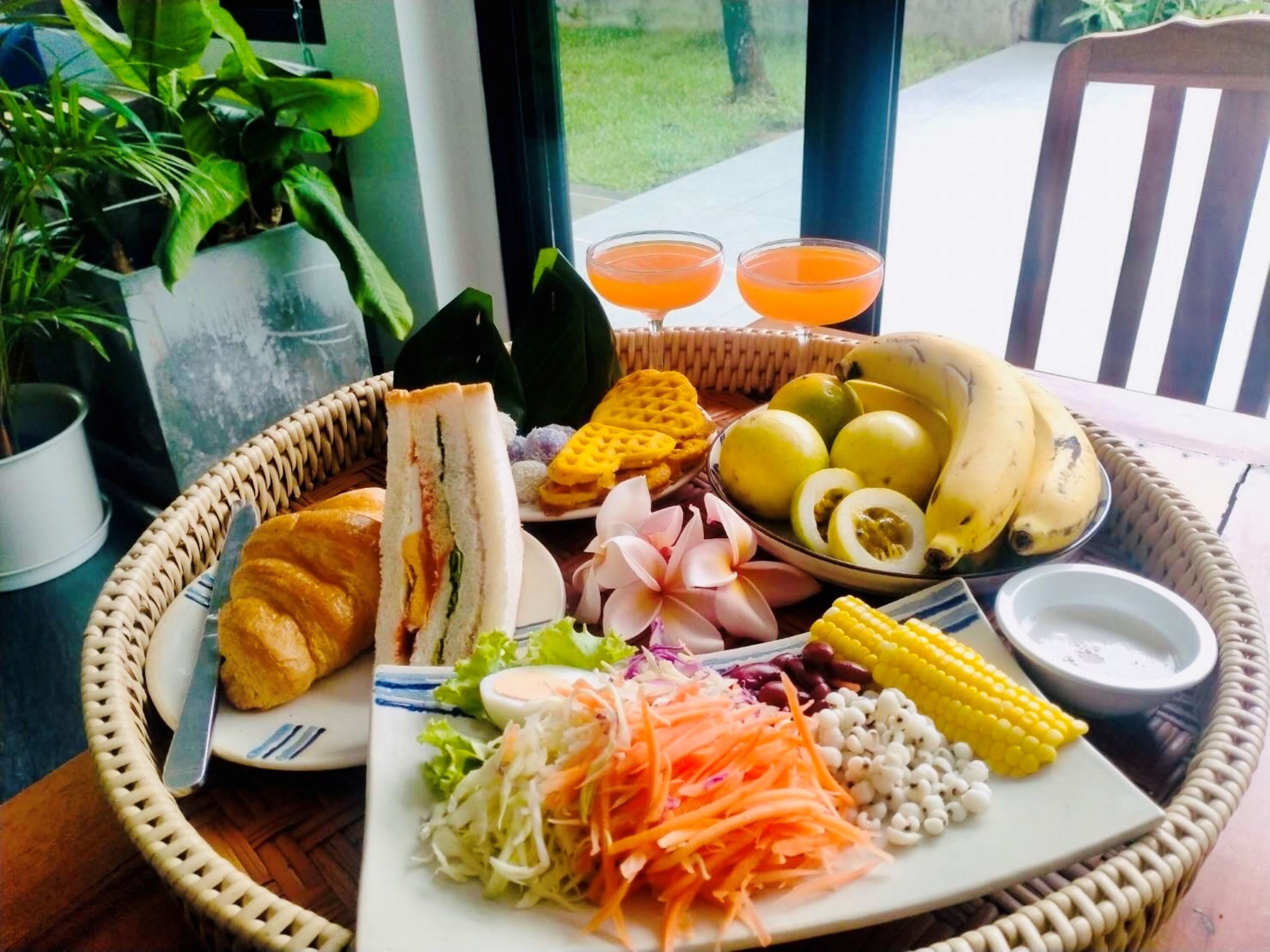 Una mesa con diversos alimentos, como sándwiches, frutas, verduras y una bebida.