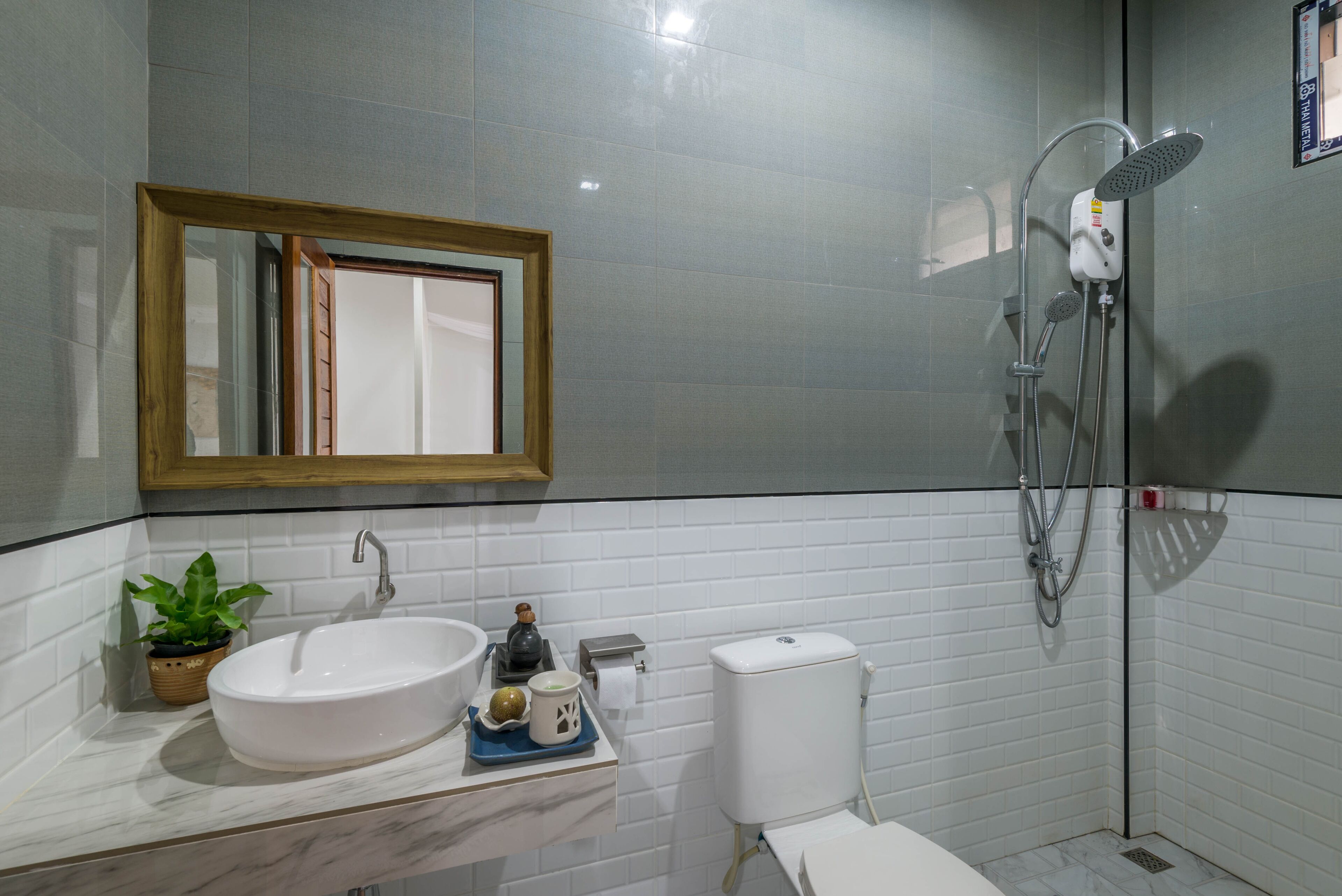 A bathroom with a white sink, a mirror, a toilet, and a shower.