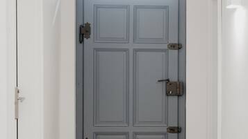 A hallway with a blue door, checkered floor, and white walls.