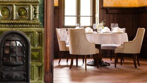 A dining area with a round table set for four, surrounded by upholstered chairs. - GUT LEBEN am Morstein (Westhofen)